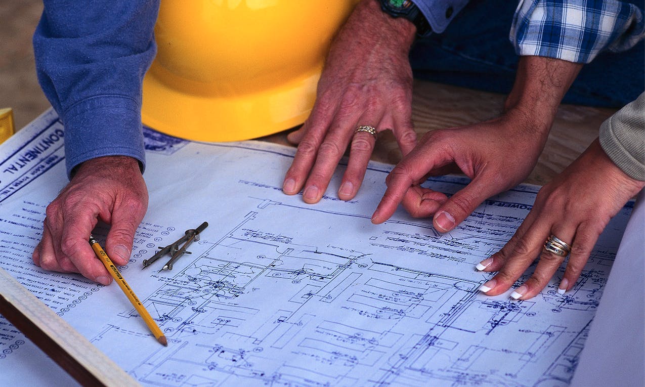Production manager reviewing plans with client