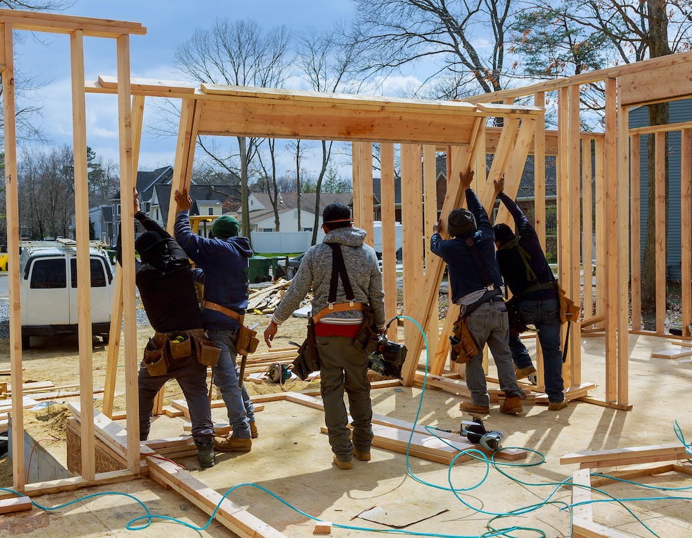 crew raising a frame on a home for remodel
