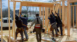 crew raising a frame on a home for remodel
