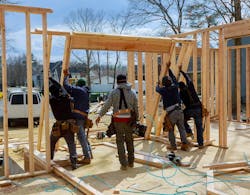 crew raising a frame on a home for remodel crew raising a frame on a home for remodel