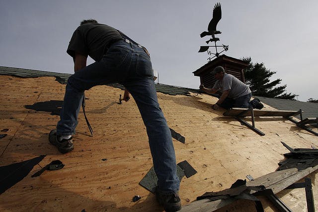 Men installing asphalt shingles