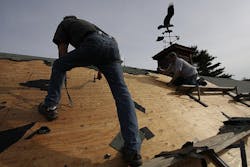 Men installing asphalt shingles Men installing asphalt shingles