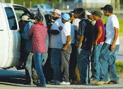 Latino workers crowd around potential hirer Latino workers crowd around potential hirer