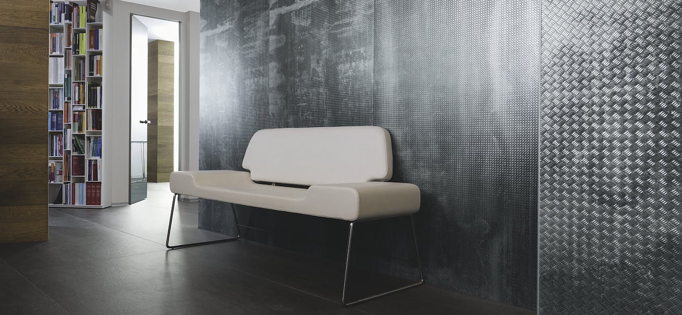 Industrial chic and reclaimed materials, such as the Metalli collection by Laminam