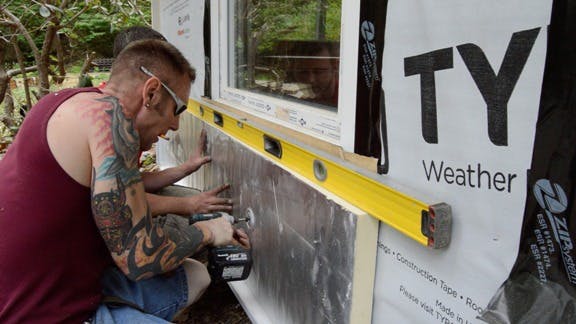 Workers leveling and fastening a rigid foam panel