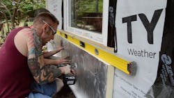 Workers leveling and fastening a rigid foam panel Workers leveling and fastening a rigid foam panel
