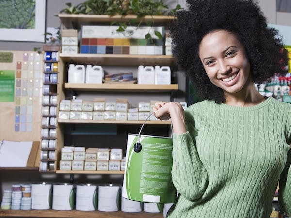 Woman holding green paint can