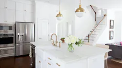 white kitchen with island, pendant lights, and cabinetry