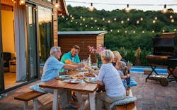 A group of people sitting at a table eating food. A group of people sitting at a table eating food.