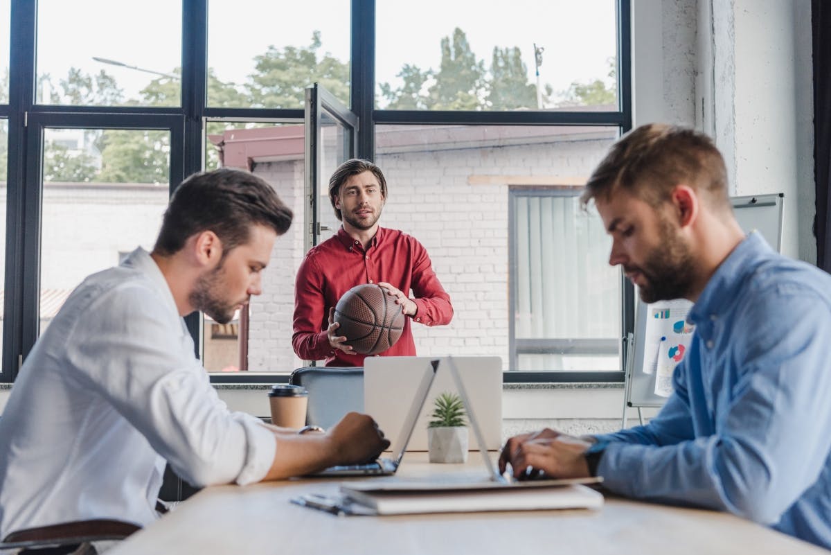 Business leaders with basketball in office