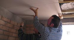 Workers install drywall in ceiling Workers install drywall in ceiling