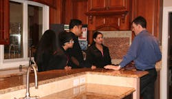 Alure Home Improvements salesperson in the showroom with customers Alure Home Improvements salesperson in the showroom with customers