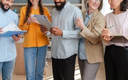 The Man In The Center Of A Group Of People Completes A Form On A Tablet The Others Hold Phones And Project Plans The Man In The Center Of A Group Of People Completes A Form On A Tablet The Others Hold Phones And Project Plans