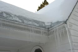 An ice dam forms on the roof of a home. An ice dam forms on the roof of a home.