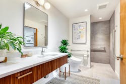 A wide turning circle in this remodeled bathroom accommodates the wheelchair used by the client’s son. Other accessible features include a wall-hung vanity, multiple grab bars, and a curb-less shower with fold-down seat and handheld shower spray. A wide turning circle in this remodeled bathroom accommodates the wheelchair used by the client’s son. Other accessible features include a wall-hung vanity, multiple grab bars, and a curb-less shower with fold-down seat and handheld shower spray.