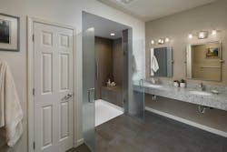 This primary bathroom was remodeled for a future wheelchair user. The reworked space includes a curbless shower that’s large enough to accommodate a caregiver if needed, a floating stone countertop, and mirrors that tilt toward a seated user. Grab bars were added throughout the space, and lighting was upgraded. A new storage closet features a jamb switch that automatically turns on the lights when the door opens. This primary bathroom was remodeled for a future wheelchair user. The reworked space includes a curbless shower that’s large enough to accommodate a caregiver if needed, a floating stone countertop, and mirrors that tilt toward a seated user. Grab bars were added throughout the space, and lighting was upgraded. A new storage closet features a jamb switch that automatically turns on the lights when the door opens.