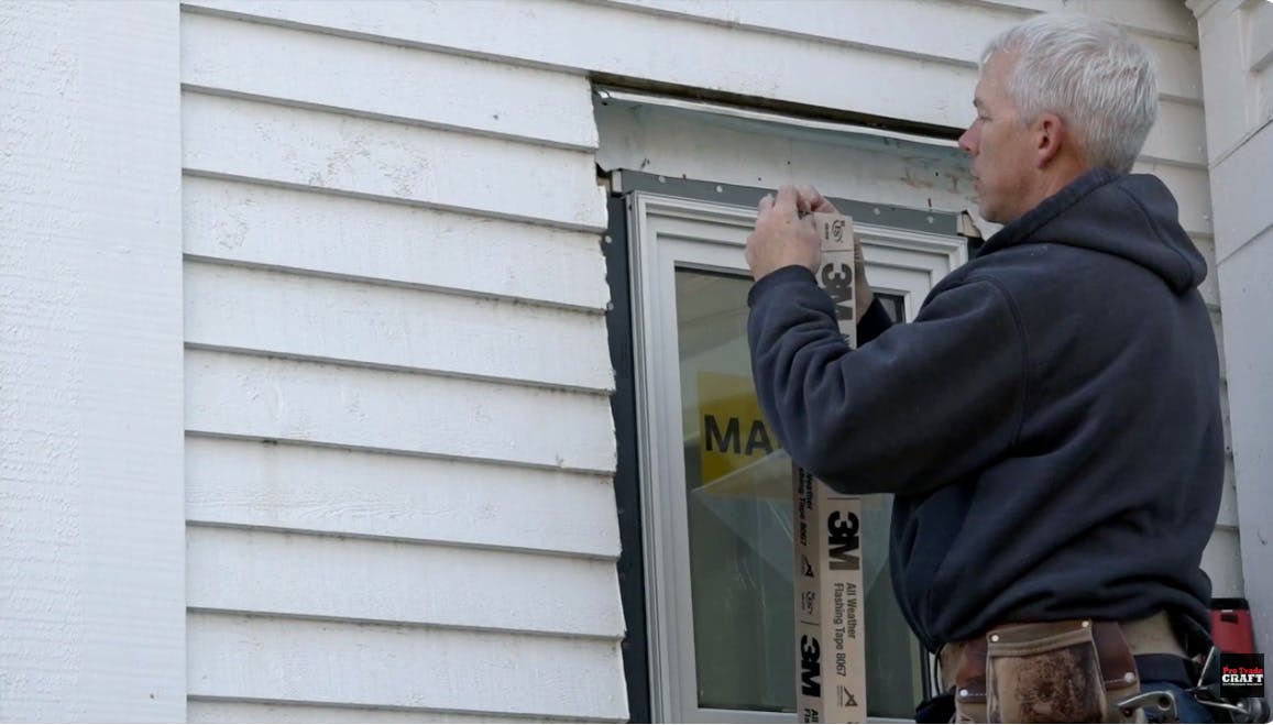 Integrating a new window into a 125-year-old wall means connecting the layers. Builder David Joyce flashes the jambs of a flanged window into the existing building wrap, which was installed about 25 years ago