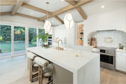 The already large kitchen (above) was opened to the rest of the house, gutted, and given a more functional layout with a huge center island. A pantry (below) with wine storage is hidden behind a wall of cabinetry. The already large kitchen (above) was opened to the rest of the house, gutted, and given a more functional layout with a huge center island. A pantry (below) with wine storage is hidden behind a wall of cabinetry.