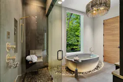Laura Sullivan and her team at ID.ology worked alongside Living Stone Design + Build to create a primary bathroom in this custom home in Flat Rock, N.C., that espouses the ideas of wellness design and, more specifically, the concept of biophilic design. Jill Jones, VP of design at ID.ology, took the lead on this project, and some of the key wellness ideas include a rain-shower head to simulate natural, gentle rainfall; soothing body jets; wood-grained tile; and pebbled flooring under foot. The soaker tub sits on a bed of illuminated river stones and offers a relaxing therapy bath with a view out to nature. The design for the home itself prioritizes health, comfort, and safety, and includes an elevator to address aging-in-place, meditation space, and water features both indoors and out—there’s a waterfall on the property. (This home’s custom-fabricated steel three-story staircase won the Gold Award for Best Design Detail in the 2025 Best in American Living Awards (BALA) from the National Association of Home Builders.) Laura Sullivan and her team at ID.ology worked alongside Living Stone Design + Build to create a primary bathroom in this custom home in Flat Rock, N.C., that espouses the ideas of wellness design and, more specifically, the concept of biophilic design. Jill Jones, VP of design at ID.ology, took the lead on this project, and some of the key wellness ideas include a rain-shower head to simulate natural, gentle rainfall; soothing body jets; wood-grained tile; and pebbled flooring under foot. The soaker tub sits on a bed of illuminated river stones and offers a relaxing therapy bath with a view out to nature. The design for the home itself prioritizes health, comfort, and safety, and includes an elevator to address aging-in-place, meditation space, and water features both indoors and out—there’s a waterfall on the property. (This home’s custom-fabricated steel three-story staircase won the Gold Award for Best Design Detail in the 2025 Best in American Living Awards (BALA) from the National Association of Home Builders.)