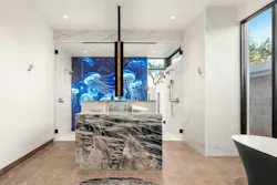 The homeowners commissioned multimedia artist Alex Turco to create the custom blue backlit shower panels for their primary bathroom (E on the floor plan). The Italian artist handcrafts his panels using photographic and digital images fused with processed materials such as aluminum, acrylic, and epoxy resins.